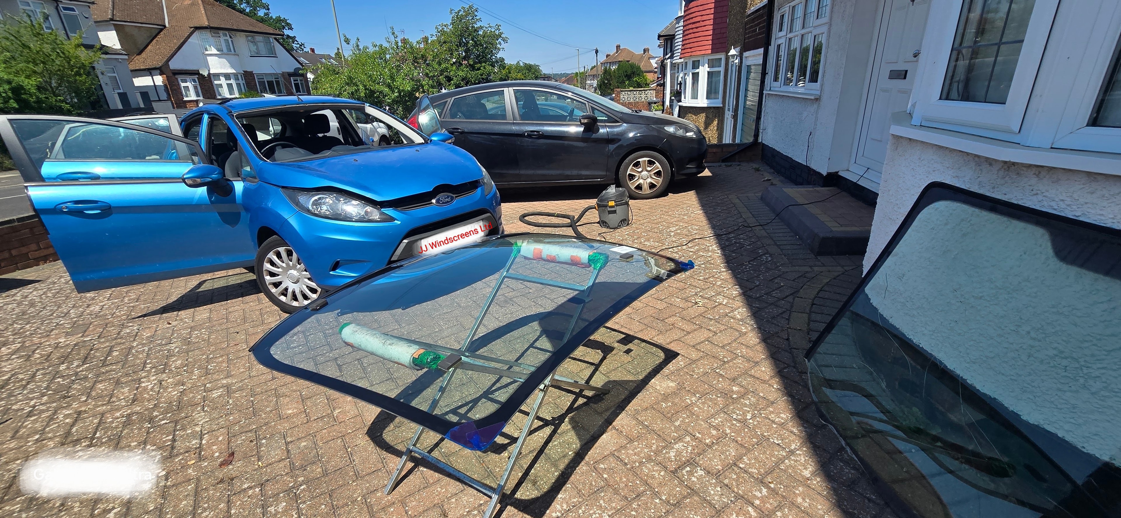JJ Windscreens technician removing old windscreen during mobile replacement job in Barnet EN4
