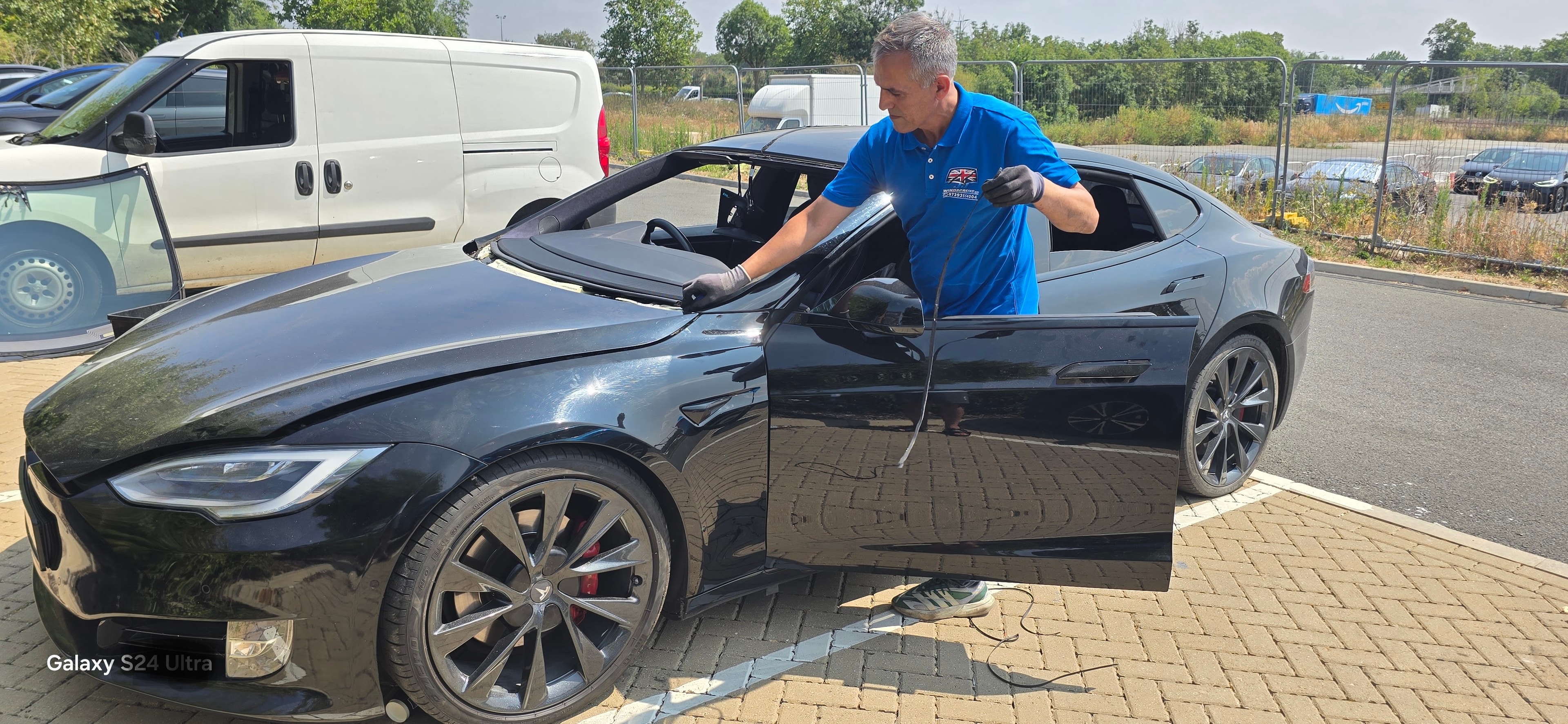 JJ Windscreens technician completing a front windscreen replacement on a black Tesla Model S in Waltham Cross EN8