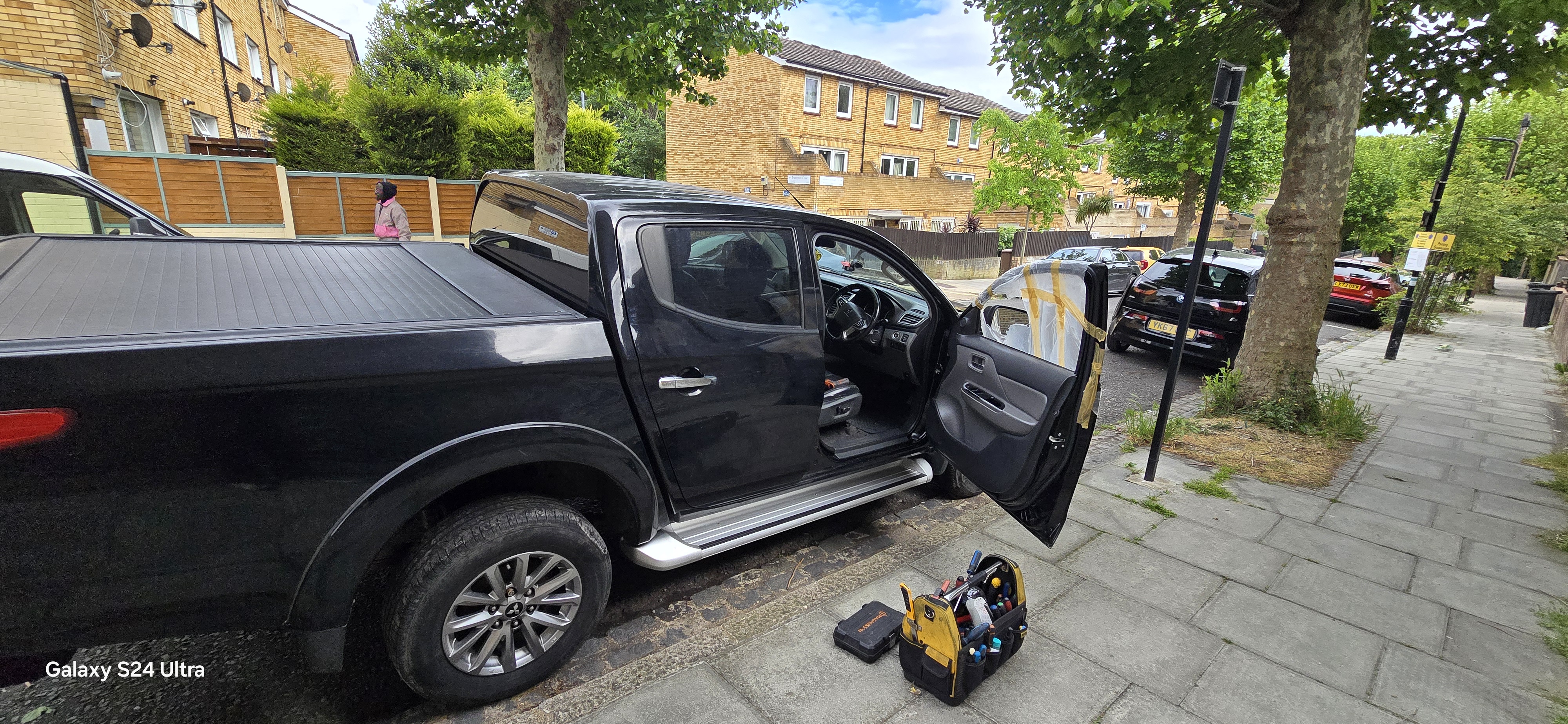 Smashed driver side door glass on Mitsubishi covered with protective plastic — door glass replacement Romford