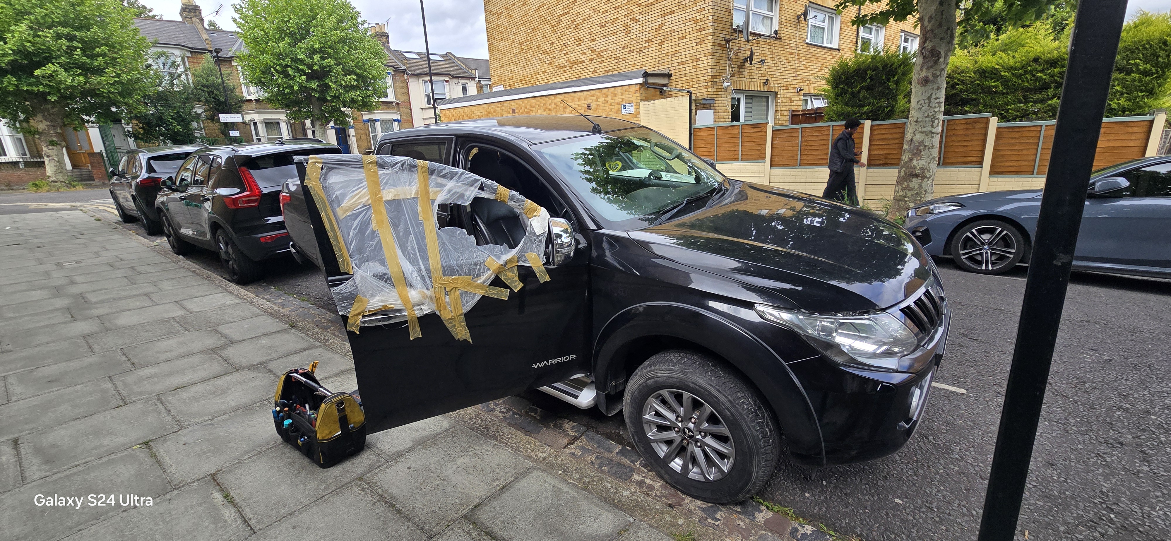 JJ Windscreens technician replacing door glass on Mitsubishi pickup truck — Romford
