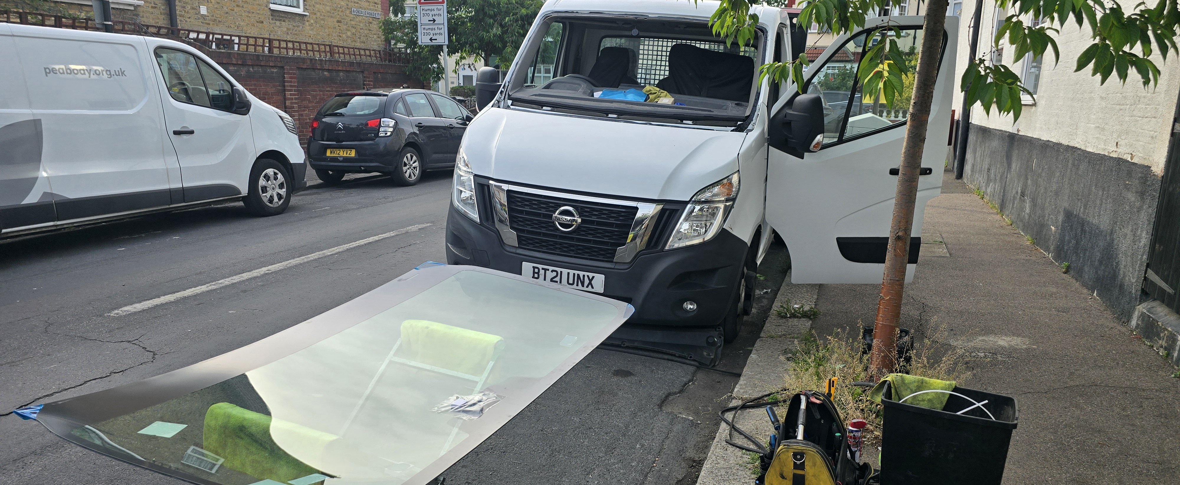 JJ Windscreens technician replacing Nissan NV400 van windscreen on-site in London